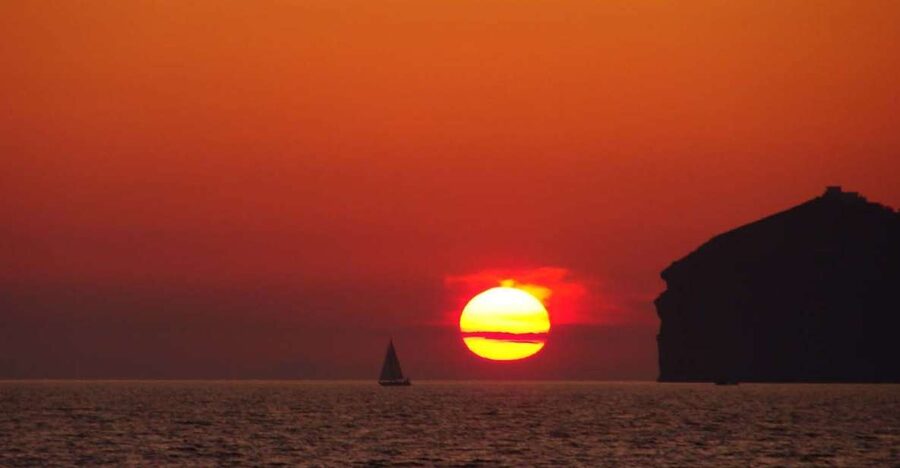 Santorini: Sunset Cruise with Greek Dinner and Transfer - The Santorini sunset from the water