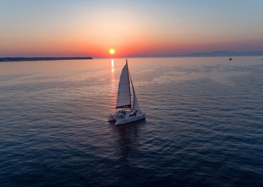 Santorini: Sunset Cruise with Swim Stops, Dinner, and Drinks - White Beach, Black Mountain Beach, and the lighthouse