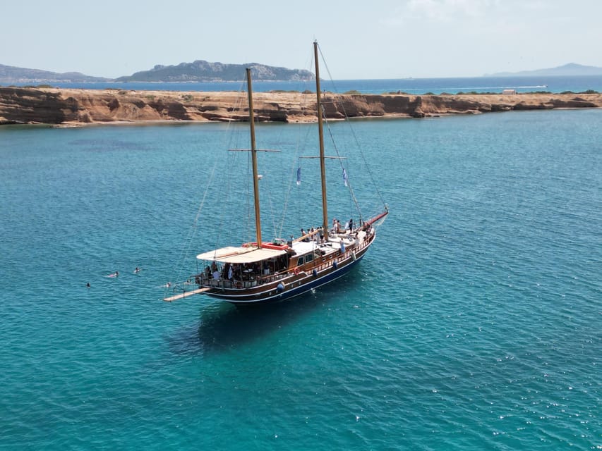 Sunset Dinner Cruise: Swim Stop, Drinks & Onboard Dining - Sailing past Vouliagmeni at golden hour
